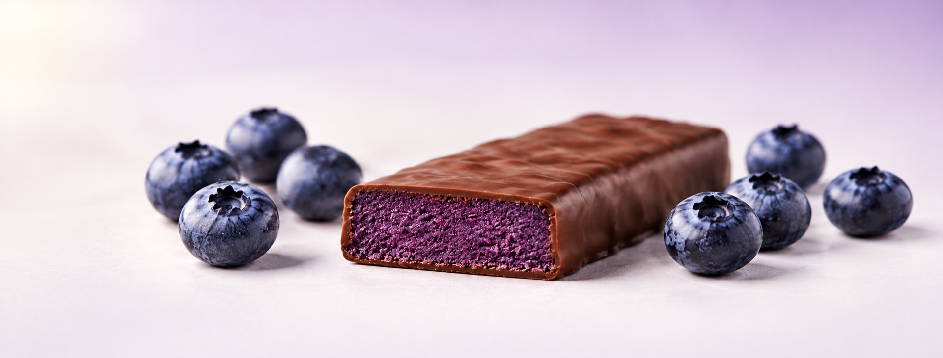Proteinová tyčinka Borůvkový cheesecake v rozkroji s borůvkami